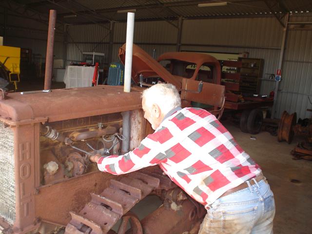 Volunteer having a closer look at the engine on the Holt Caterpillar