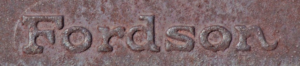 close-up of rusty Fordson cast iron brand on tractor